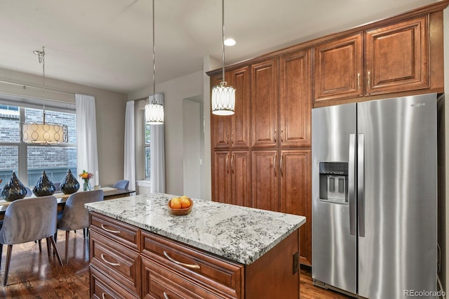 8741 E 29th Ave, Denver, CO 80238 - kitchen with dark wood finished floors, stainless steel fridge with ice dispenser, light stone countertops, hanging light fixtures, and a kitchen island