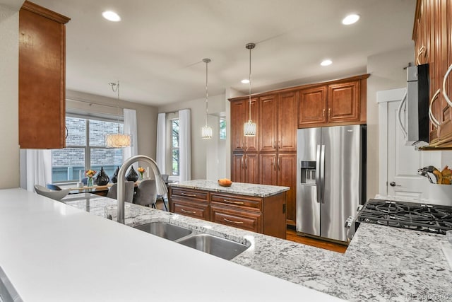 8741 E 29th Ave, Denver, CO 80238 - kitchen featuring brown cabinets, a sink, pendant lighting, appliances with stainless steel finishes, and dark wood-style floors