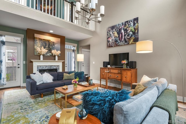 8741 E 29th Ave, Denver, CO 80238 - living room with baseboards, a stone fireplace, a notable chandelier, and wood finished floors