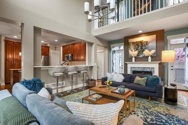 8741 E 29th Ave, Denver, CO 80238 - living area with baseboards, a stone fireplace, visible vents, and wood finished floors