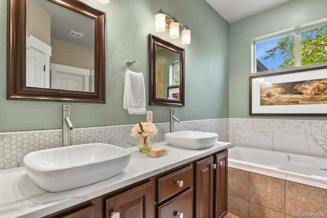 8741 E 29th Ave, Denver, CO 80238 - bathroom featuring double vanity, a garden tub, visible vents, and a sink