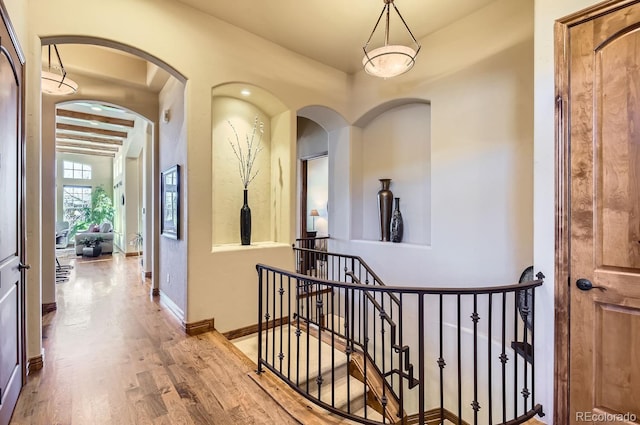 hallway with beam ceiling and hardwood / wood-style flooring