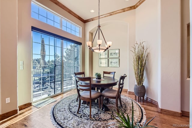 dining room featuring hardwood / wood-style flooring, ornamental molding, and a notable chandelier