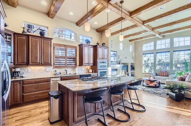 kitchen featuring tasteful backsplash, a kitchen island, a healthy amount of sunlight, and sink