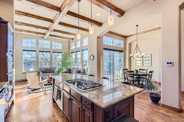 kitchen featuring appliances with stainless steel finishes, light hardwood / wood-style floors, a kitchen island, and a wealth of natural light