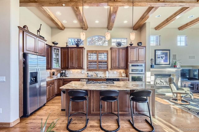 kitchen featuring a large island, plenty of natural light, backsplash, and appliances with stainless steel finishes