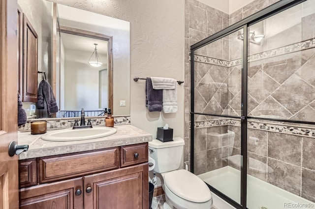 bathroom featuring toilet, vanity, and walk in shower