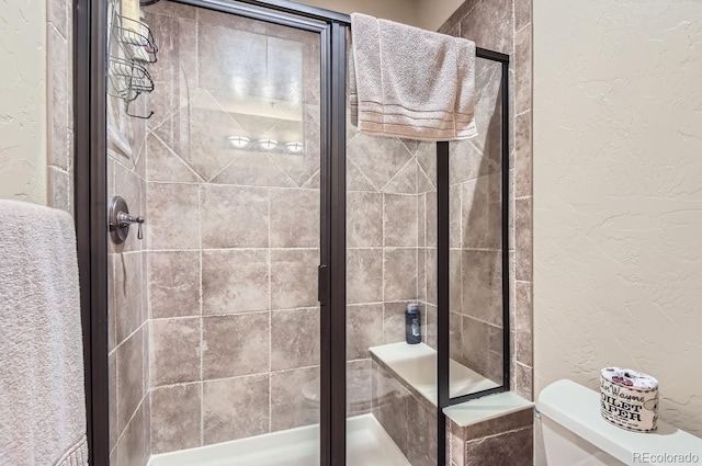 bathroom with toilet and an enclosed shower