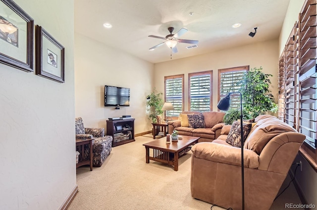 carpeted living room with ceiling fan