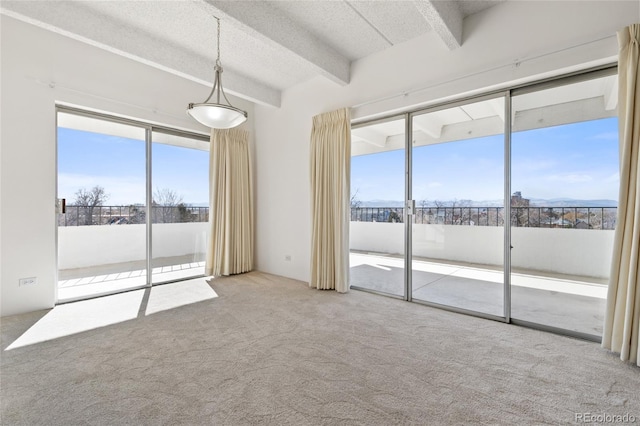 carpeted spare room with a textured ceiling and beam ceiling