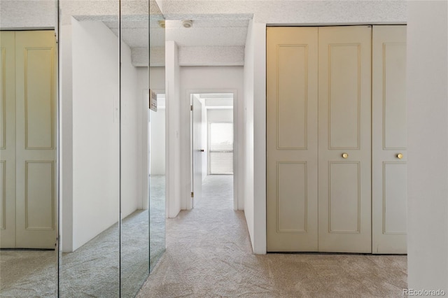 corridor featuring light colored carpet