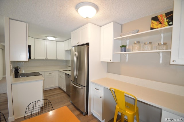 kitchen featuring light wood-type flooring, white cabinets, and appliances with stainless steel finishes