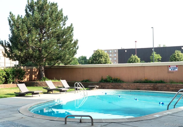 view of swimming pool featuring a patio area and fence