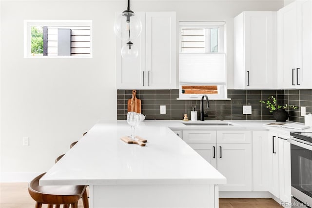 3955 W 13th Ave, Denver, CO 80204 - kitchen with healthy amount of natural light, decorative backsplash, a breakfast bar, and light countertops