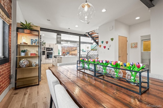 dining space with visible vents, recessed lighting, brick wall, and light wood-type flooring