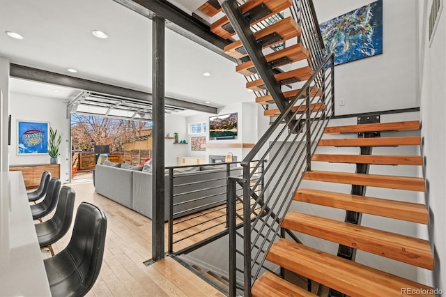 staircase featuring recessed lighting, visible vents, plenty of natural light, and hardwood / wood-style floors