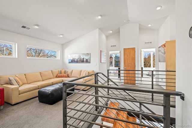 living room featuring a wealth of natural light, visible vents, and lofted ceiling