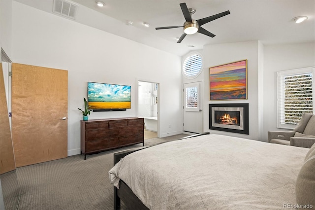 bedroom featuring visible vents, high vaulted ceiling, a warm lit fireplace, carpet, and baseboards