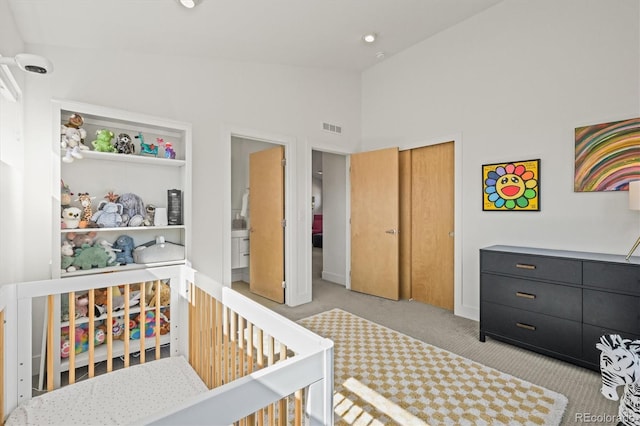 bedroom featuring visible vents, a crib, high vaulted ceiling, a closet, and carpet