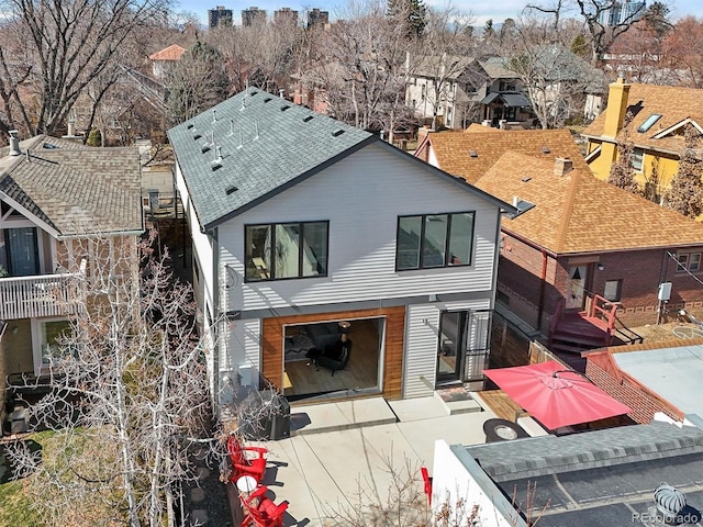 rear view of house with a residential view and a shingled roof