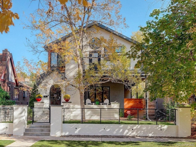 view of front of house with a fenced front yard and a gate