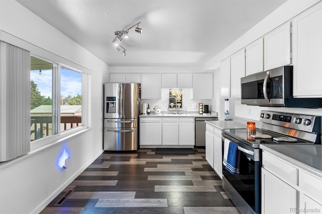 1261 Eagle St, Aurora, CO 80011 - kitchen featuring stainless steel appliances, light countertops, white cabinets, and dark wood-type flooring