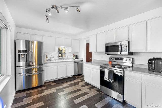1261 Eagle St, Aurora, CO 80011 - kitchen with appliances with stainless steel finishes, white cabinetry, light countertops, and dark wood-style floors