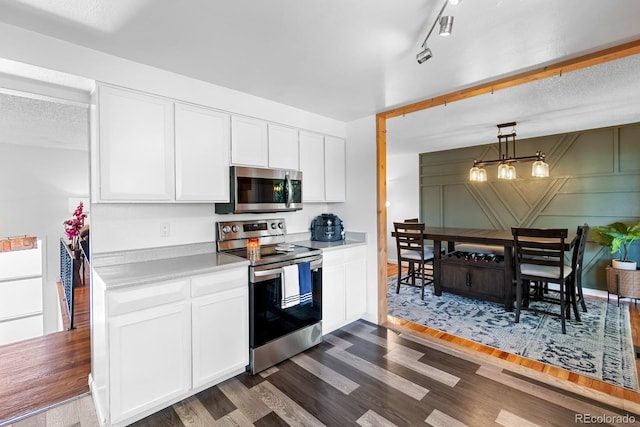 1261 Eagle St, Aurora, CO 80011 - kitchen featuring stainless steel appliances, dark wood-style floors, white cabinetry, light countertops, and pendant lighting