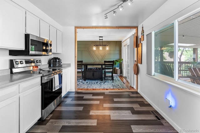 1261 Eagle St, Aurora, CO 80011 - kitchen featuring appliances with stainless steel finishes, a chandelier, dark wood finished floors, white cabinetry, and light countertops