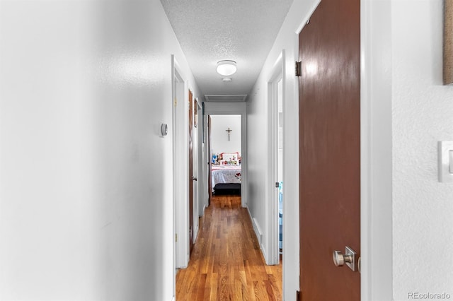 1261 Eagle St, Aurora, CO 80011 - corridor with a textured ceiling and light wood-style floors