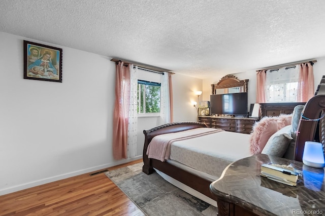 1261 Eagle St, Aurora, CO 80011 - bedroom with a textured ceiling and wood finished floors