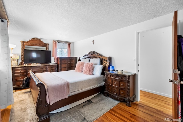 1261 Eagle St, Aurora, CO 80011 - bedroom featuring a textured ceiling and wood finished floors