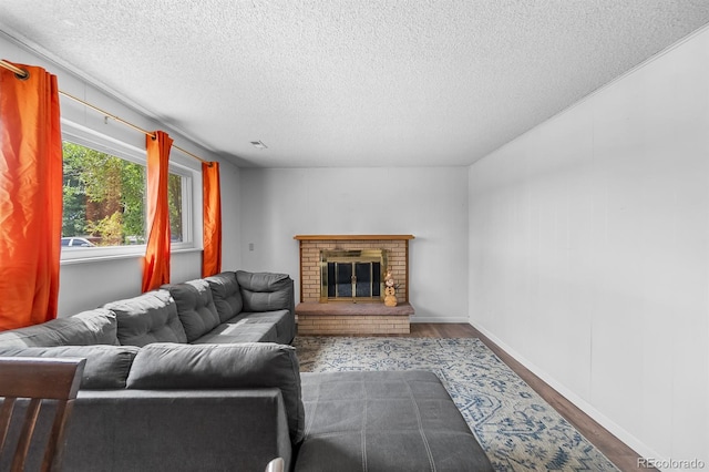 1261 Eagle St, Aurora, CO 80011 - living room featuring wood finished floors, a textured ceiling, and a brick fireplace