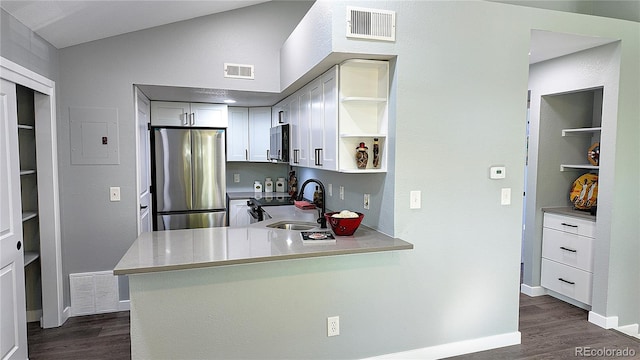 kitchen with kitchen peninsula, appliances with stainless steel finishes, dark hardwood / wood-style flooring, and sink