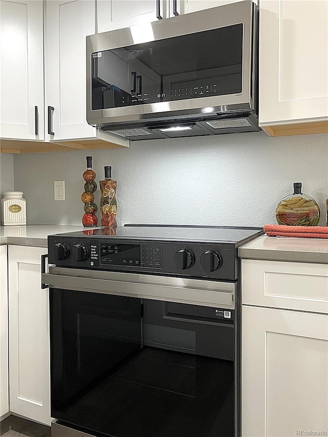 kitchen featuring white cabinets and electric range