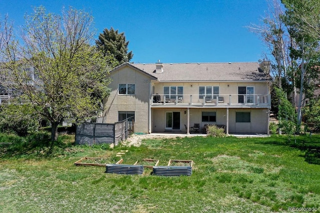 10042 Rolling Ridge Rd, Colorado Springs, CO 80925 - back of house featuring a vegetable garden, a patio, a balcony, and stucco siding