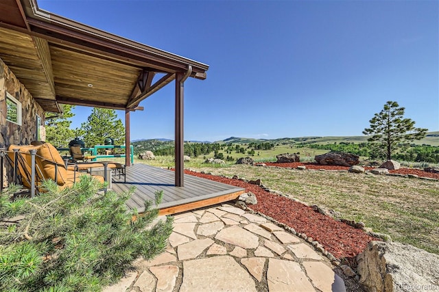 view of patio / terrace featuring a deck with mountain view and a rural view