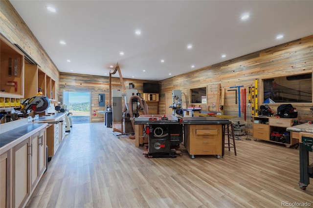 kitchen featuring light hardwood / wood-style floors, a breakfast bar, wooden walls, and a kitchen island