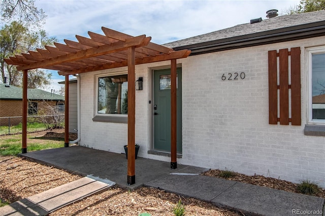 6220 W 11th Pl, Lakewood, CO 80214 - doorway to property with brick siding, a pergola, a patio area, and roof with shingles