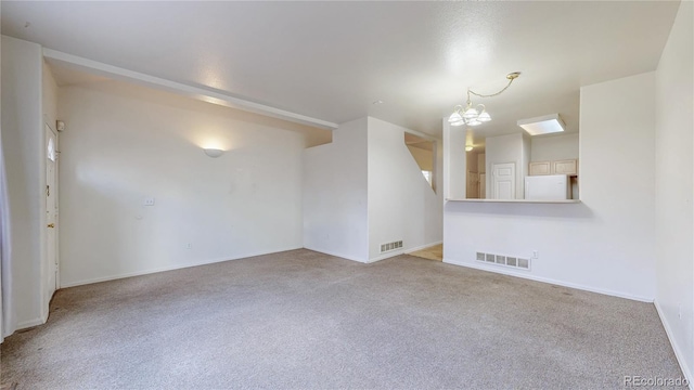 empty room with baseboards, carpet floors, visible vents, and an inviting chandelier