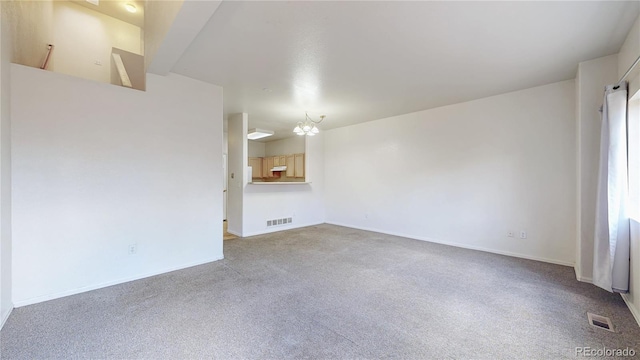 empty room featuring carpet, visible vents, and baseboards