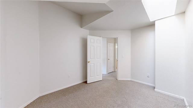 empty room featuring light carpet and baseboards