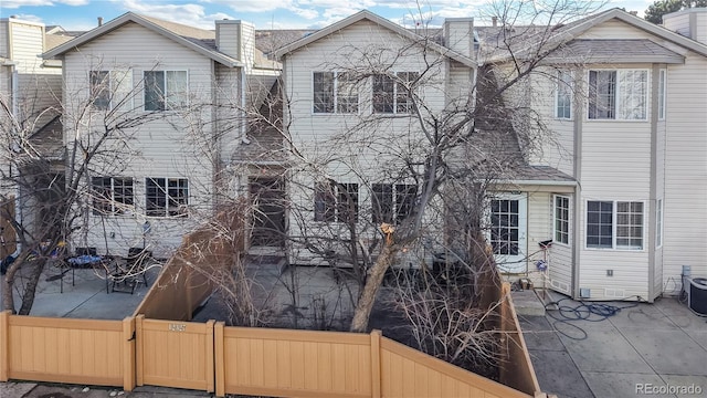 multi unit property with a patio area, fence, and a chimney