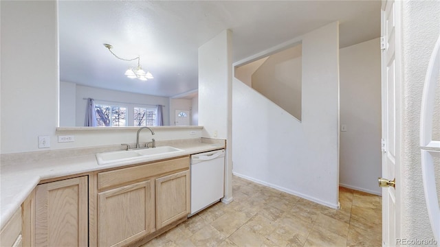 kitchen with an inviting chandelier, light countertops, a sink, white dishwasher, and light brown cabinets