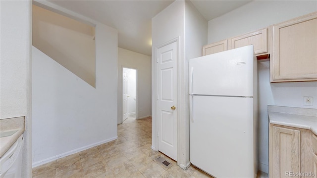 kitchen featuring baseboards, white appliances, light countertops, visible vents, and light brown cabinetry