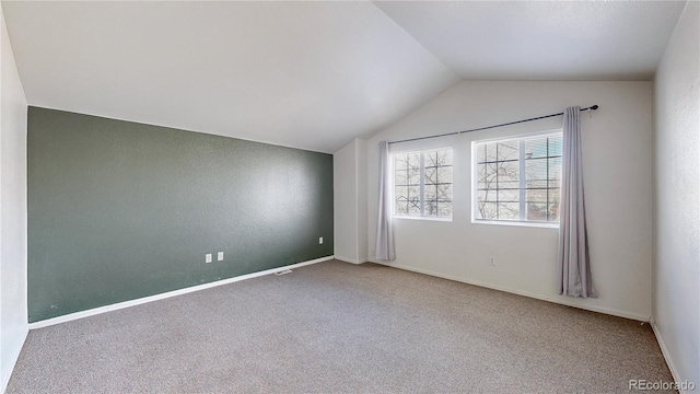 unfurnished room featuring carpet, baseboards, and lofted ceiling