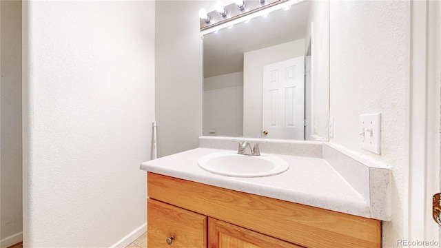bathroom with vanity and a textured wall