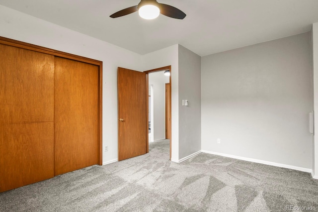 unfurnished bedroom with ceiling fan, a closet, and light carpet