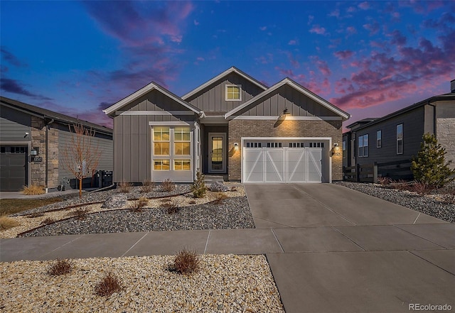 craftsman house featuring an attached garage, brick siding, board and batten siding, and concrete driveway