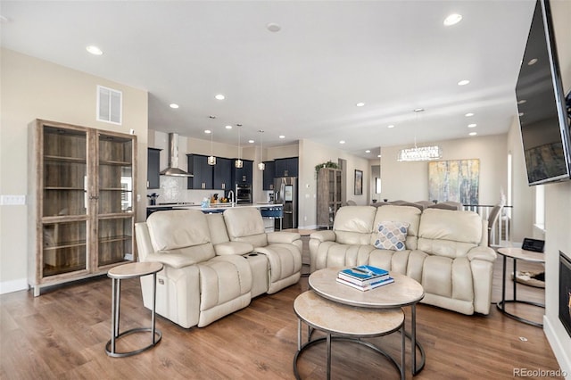 living room featuring recessed lighting, visible vents, baseboards, and wood finished floors